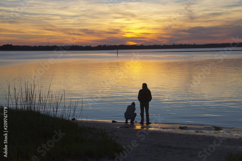 Couple Enjoys the Wonders of Planet Earth As the Sun Sets Over the Bay Behind Them