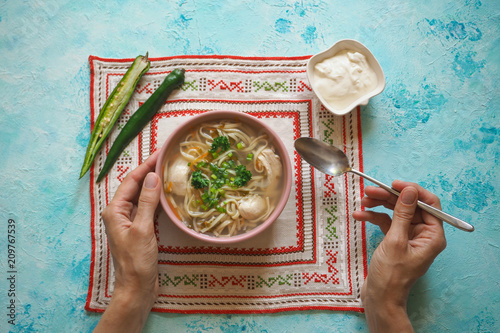 Zama, romanian and moldavian chicken soup with noodle. Traditional hangover soup is served with hot pepper and sour cream photo