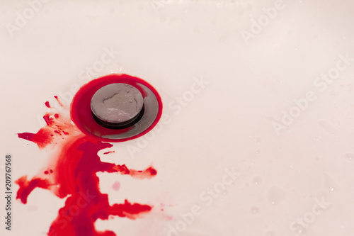 Bleeding blood on white floor of sink in bathroom, hemophobia concept photo