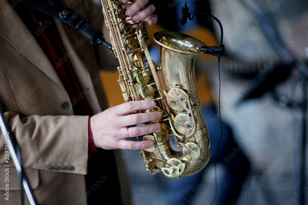 Obraz premium The hands of a professional musician, playing the saxophone on stage