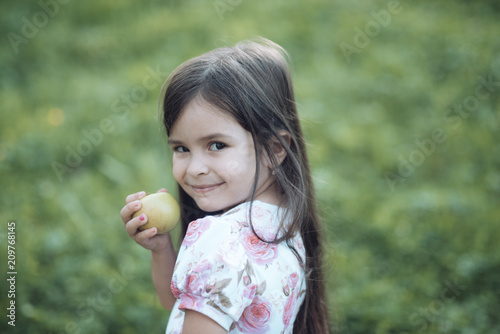 Child smile with green apple fruit on nature, food