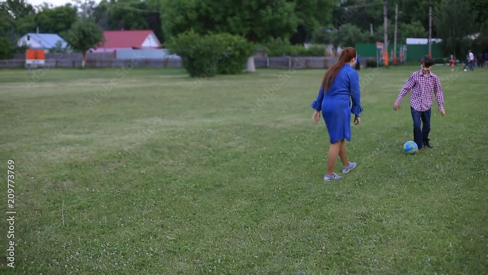 Little baby boy and his mother playing with the soccer ball at football field. Little baby boy and his mother playing with the soccer ball at football field.