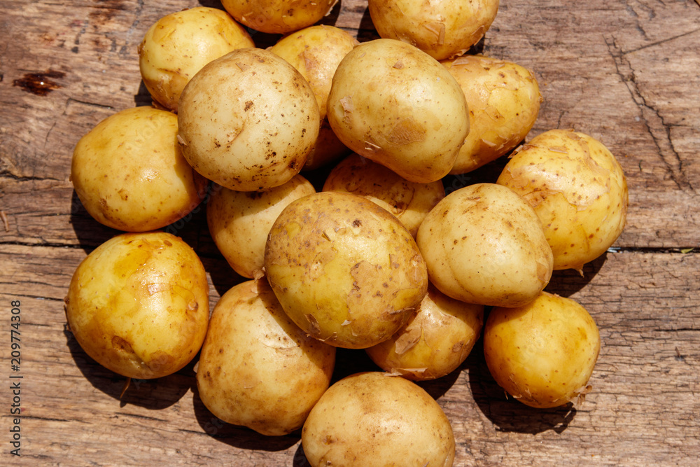 New potatoes on rustic wooden table New potatoes on rustic wooden table