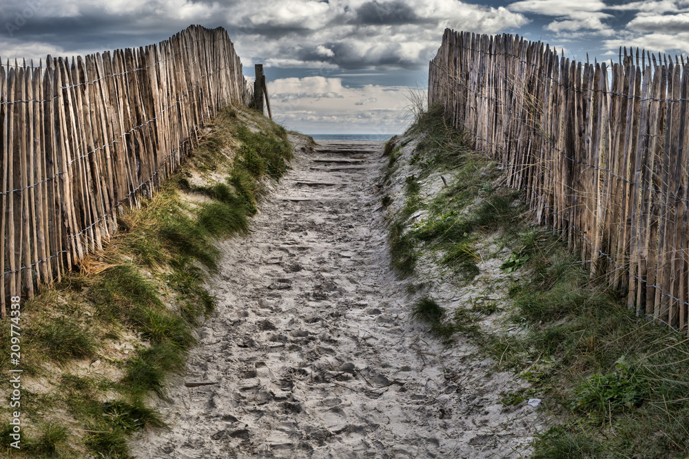 Sand covered foothpath with peculiar palisade coastline in Brittany, near the atlantic ocean, France Sand covered foothpath with peculiar palisade coastline in Brittany, near the atlantic ocean, France