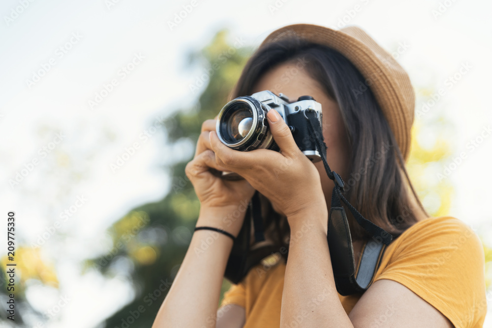 Young woman using a camera to take photo. Young woman using a camera to take photo.