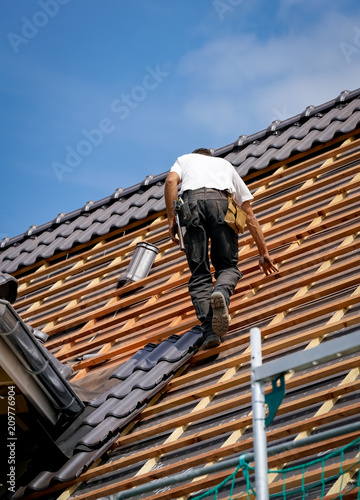 Dachdecker auf dem Dach eines neuen Wohnhauses, Hochformat