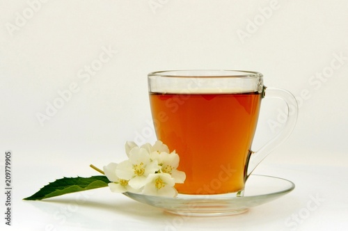 A сup of fragrant tea with aromatic jasmine flowers.