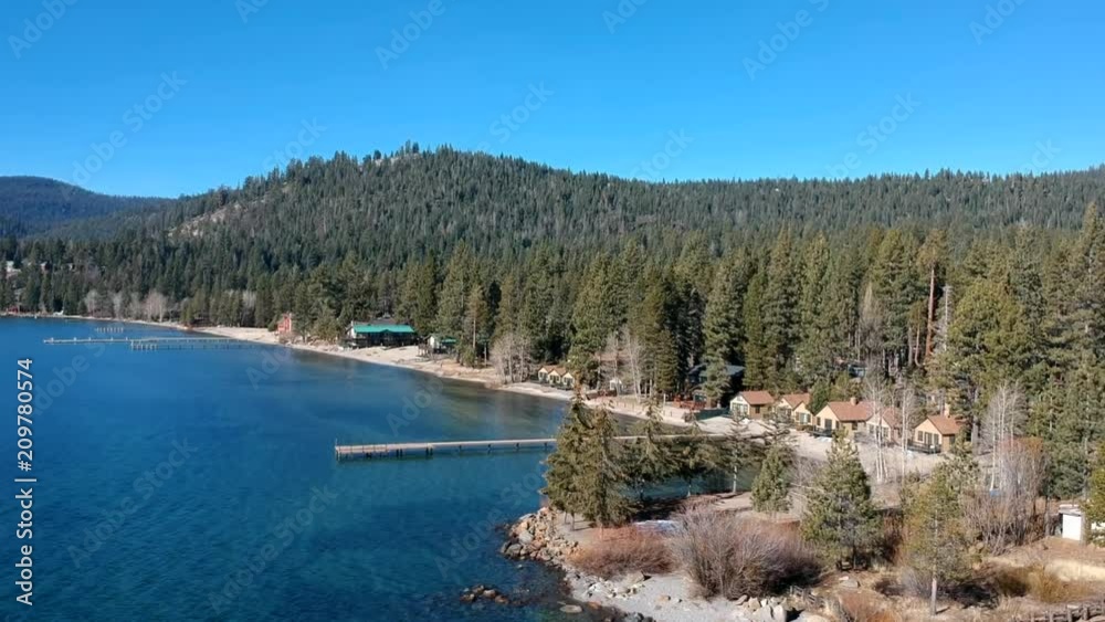 Drone shot/aerial view of shoreline of Lake Tahoe during the day. Beautiful clear skies, forest, and lake/beach. Drone shot/aerial view of shoreline of Lake Tahoe during the day. Beautiful clear skies, forest, and lake/beach.