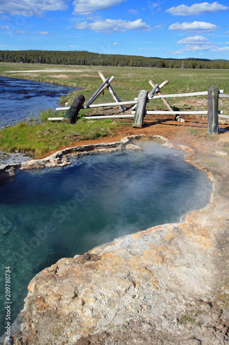 Maidens Grave Hot Spring flowing into the Firehole River in Yellowstone National Park in Wyoming United States photo