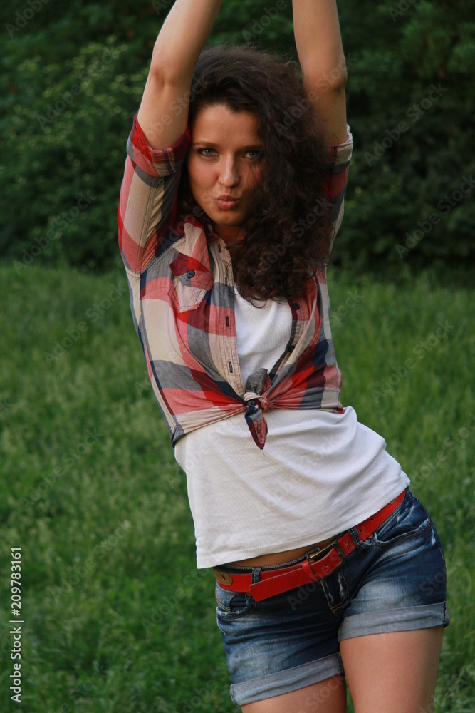 Young woman with dark curly hair. Young woman in the nature. Young woman with dark curly hair. Young woman in the nature.