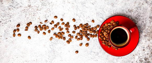 Foto auf Leinwand Küche Kaffeebohnen duftend in der roten Tasse auf dem grauen Hintergrund. Ansicht von oben. Kopieren Sie Platz für Text.Banner  © lily_rocha
