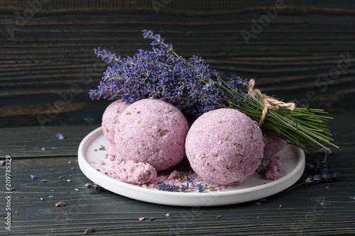Lavender bath bombs and beautiful lavender flowers on dark wooden table. Natural skincare cosmetics.