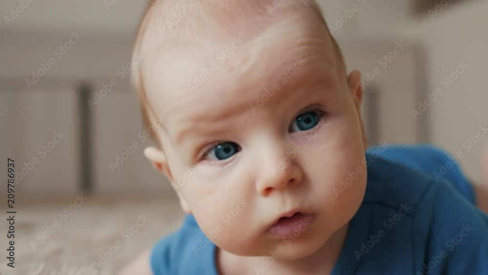 happy newborn baby on the bed at home, portrait of child man in bedroom, small kid man boy