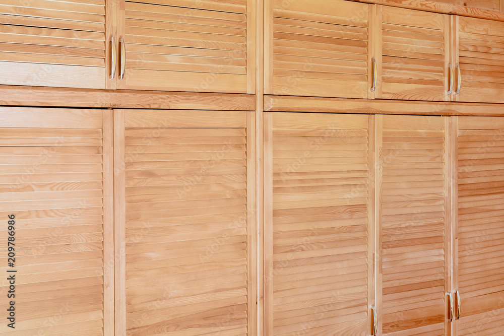 Modern wooden cabinet in classic rustic style. Details of wardrobe case with shutter plank doors. Country house interior Modern wooden cabinet in classic rustic style. Details of wardrobe case with shutter plank doors. Country house interior