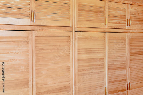 Modern wooden cabinet in classic rustic style. Details of wardrobe case with shutter plank doors. Country house interior
