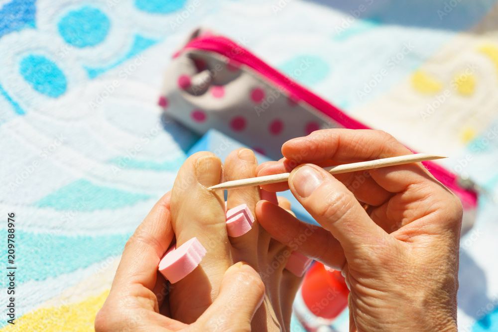 Woman pushing cuticles before pedicure Woman pushing cuticles before pedicure