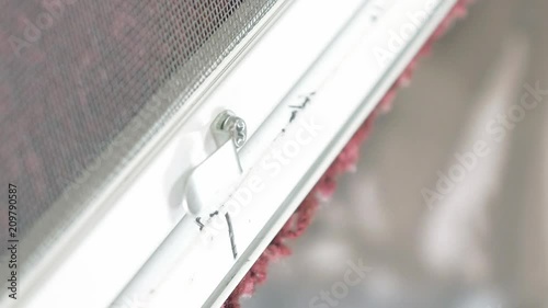Close up shot of man's hands screwing by screw gun screwdriver bolts in aluminum profile. Using tools in manufacture of mosquito net for plastic windows. Vertical format video.