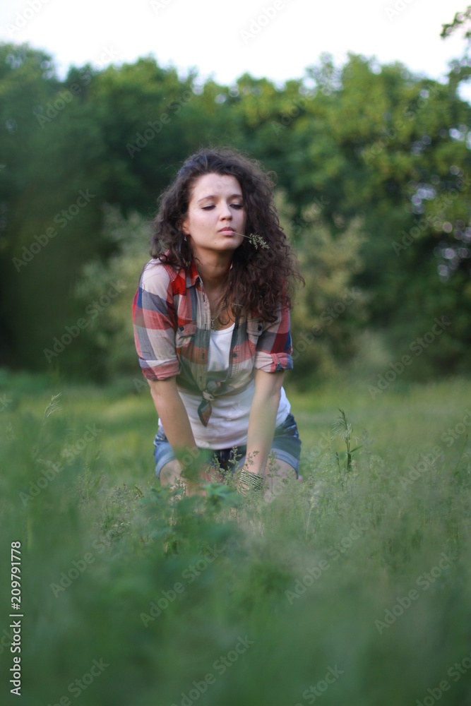 Young, beautiful woman on nature. Young woman with dark curly hair. Young, beautiful woman on nature. Young woman with dark curly hair.