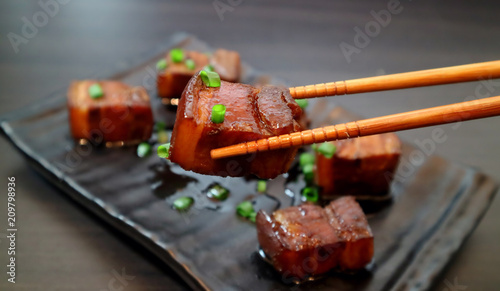 Braised pork belly oriental style food appetizer on dark background. Selective focus. photo