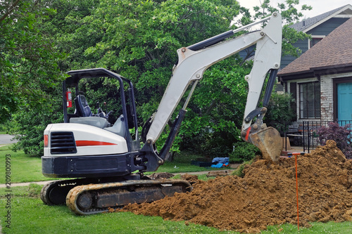 Major homeowner problem: Excavator digging out lawn to access water main problem leading to house.