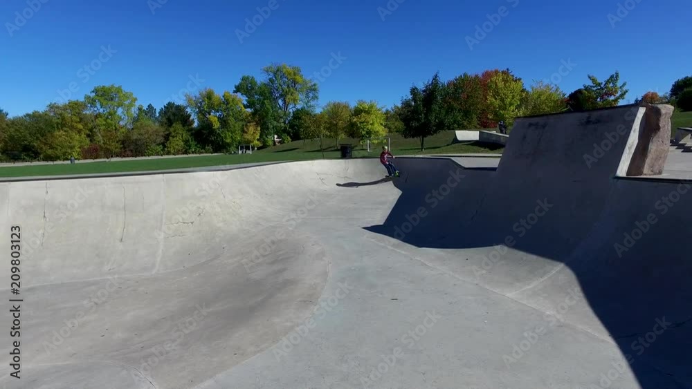 Boys riding scooters at the skate park