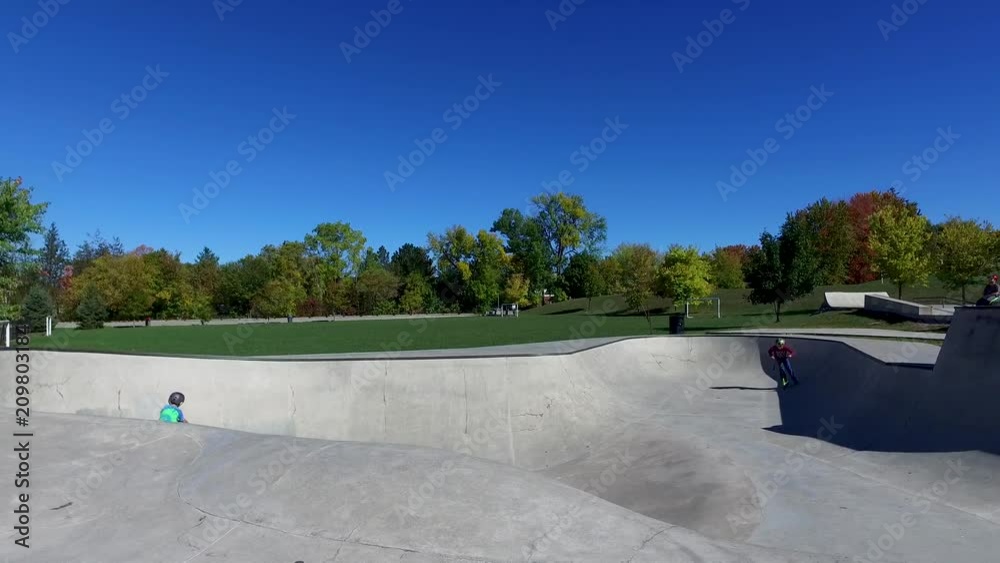 Boys riding scooters at the skate park