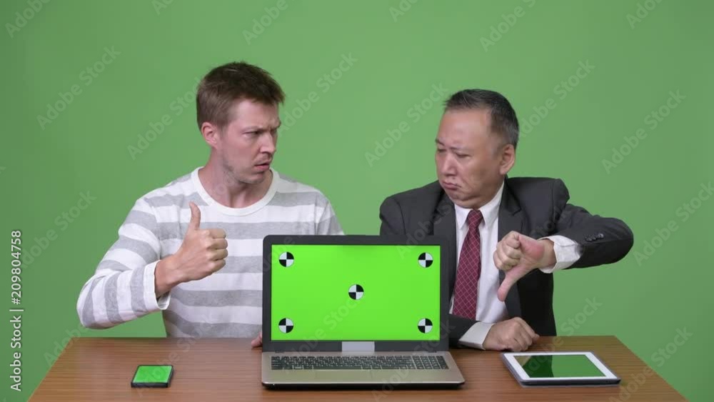 Mature Japanese businessman and young Scandinavian businessman working together Mature Japanese businessman and young Scandinavian businessman working together