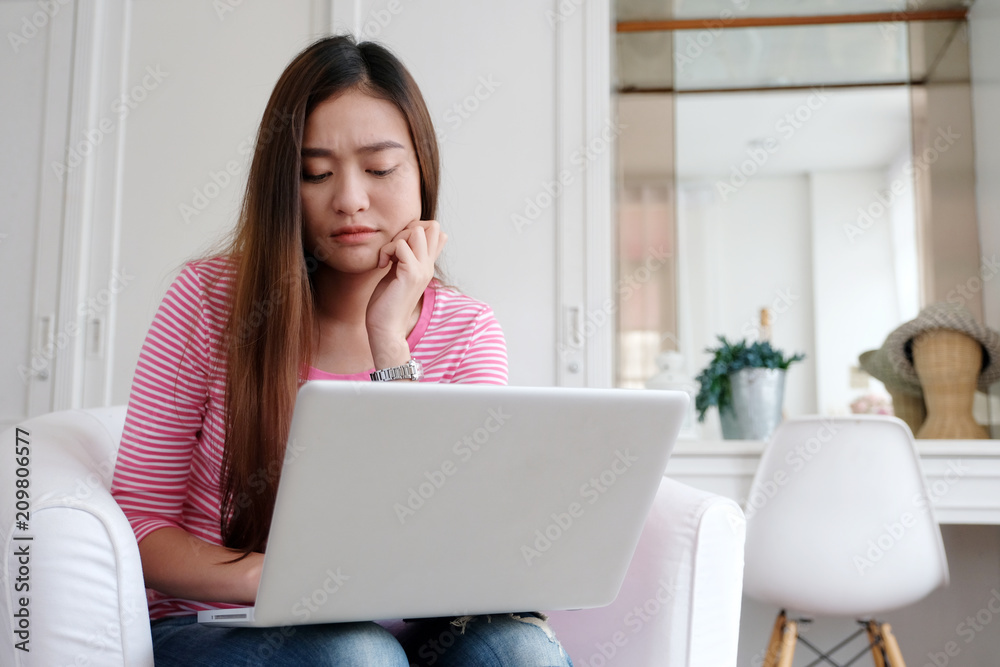 Young asian woman with frustrated expression while working with laptop computer, working from home, casual office lifestyle Young asian woman with frustrated expression while working with laptop computer, working from home, casual office lifestyle