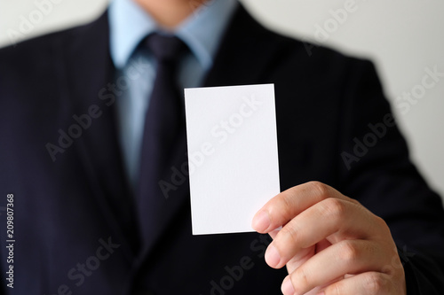 Businessman hand holding blank white business card with copy space for text, business mock up background concept