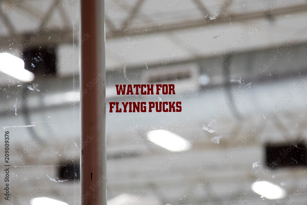Naklejka premium Warning to Watch for Flying Pucks at an ice hockey rink