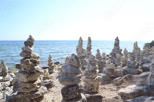 Inspiring stacked rock towers balancing on a zen beach © Jackie
