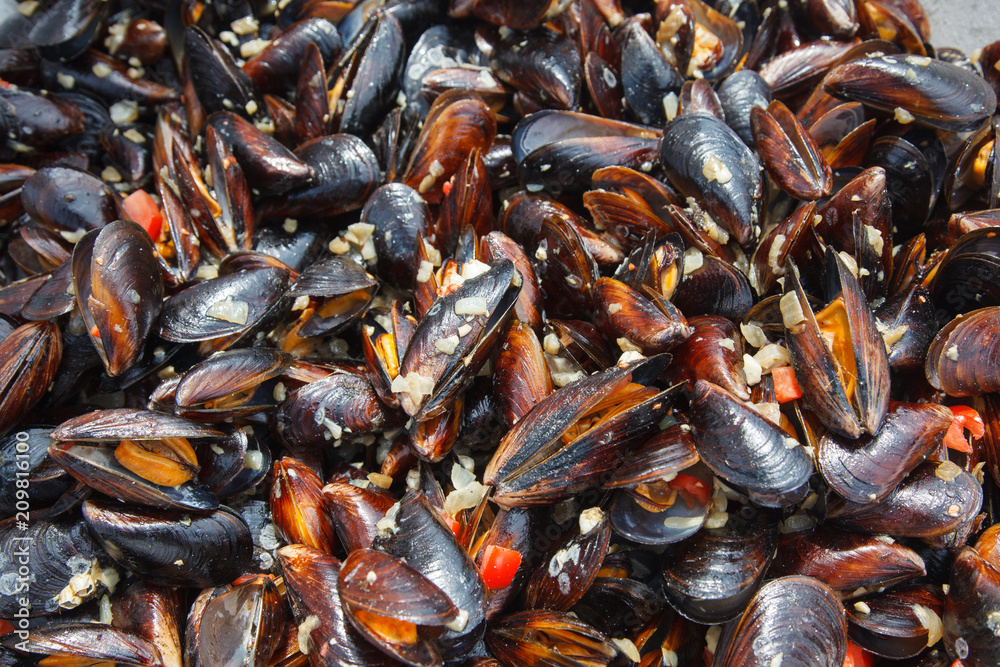 Mussels cooked in sauce with vegetables in a frying pan Mussels cooked in sauce with vegetables in a frying pan