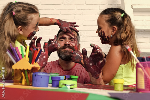Wallpaper Mural children have fun with their father. Girls drawing on man face skin with colorful paints Torontodigital.ca