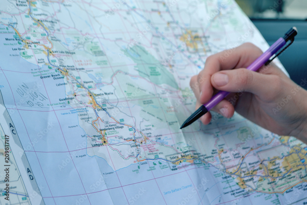 Pointing and planning a road trip on a paper travel map Pointing and planning a road trip on a paper travel map