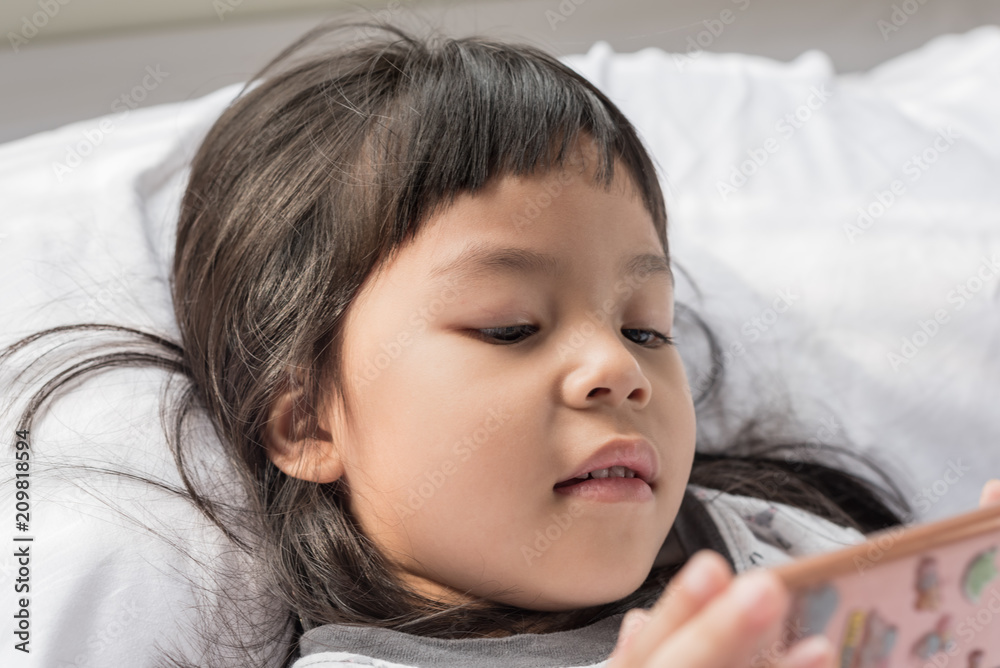 Cute Little girl using mobile phone at home Cute Little girl using mobile phone at home