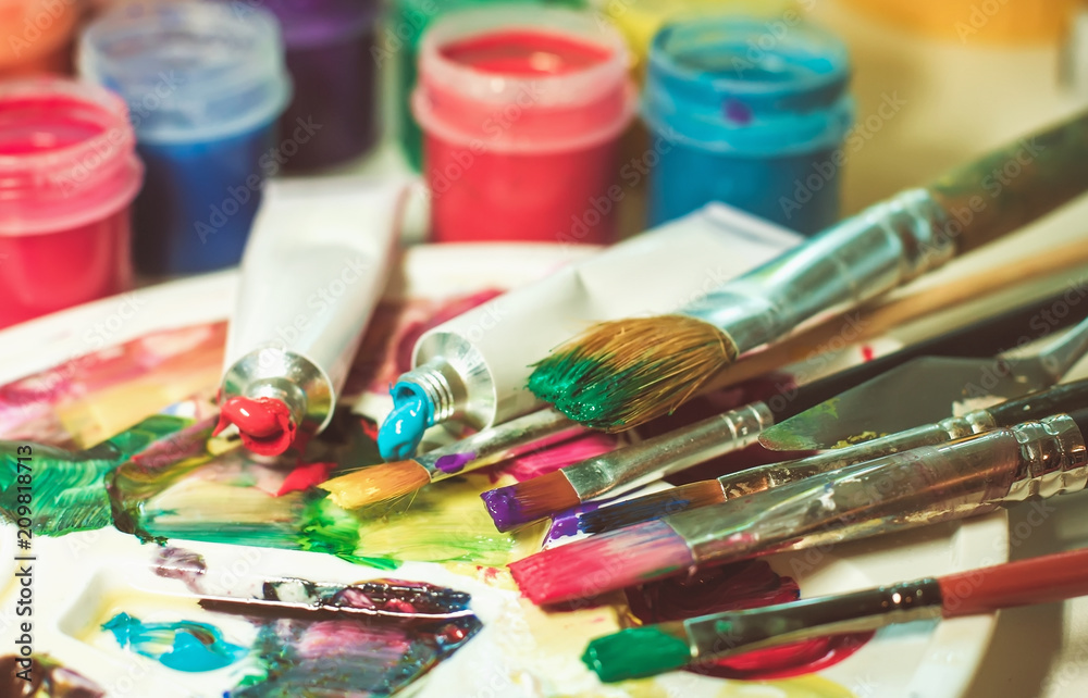 group of used brushes and a color palette. artist set of ideas of creative inspiration. a palette with paint and brushes group of used brushes and a color palette. artist set of ideas of creative inspiration. a palette with paint and brushes