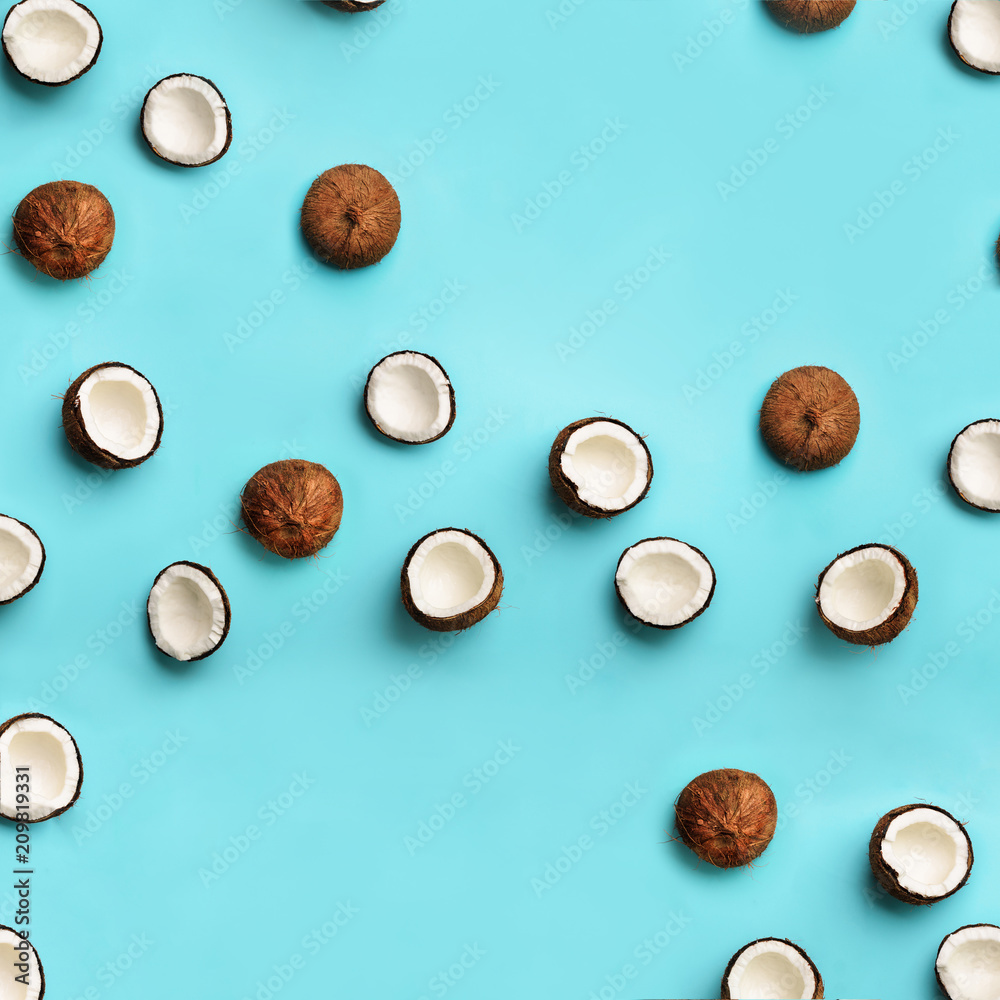 Pattern with ripe coconuts on blue background. Square crop. Top View. Copy Space. Pop art design, creative summer concept. Half of coconut in minimal flat lay style. Pattern with ripe coconuts on blue background. Square crop. Top View. Copy Space. Pop art design, creative summer concept. Half of coconut in minimal flat lay style.