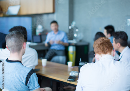 A Manager Presenter with Both Hands Up and Fingertips Pointing at Each Other is Meeting with a Group and Giving a Presentation. Business Meeting with Group of People.