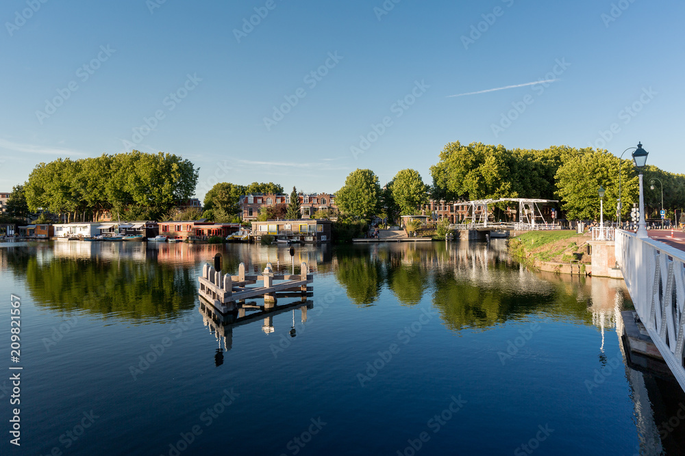 Obraz premium Waterview with mix of elements such as floating houses and bridge reflected in the water