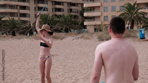 Young couple playing smash ball beach tennis
