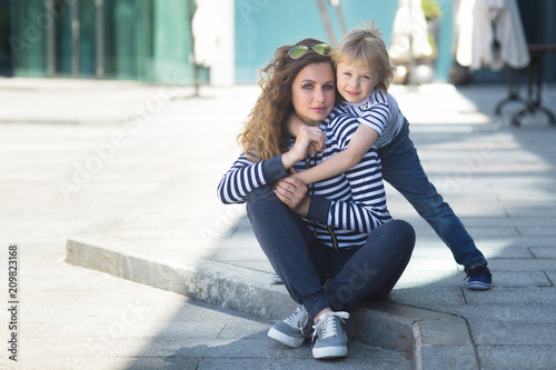 Young pretty mother and her son having fun outdoors. Cute child and his mom spending time together. Adorable kid and cheerful mum.