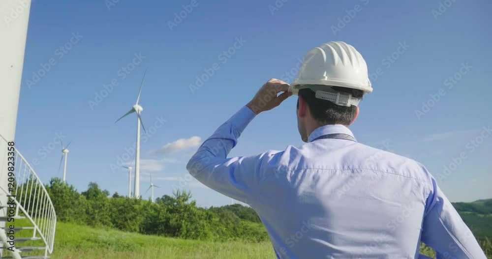 An engineer controls the functioning of wind turbines that run thanks to the force of the wind and generate electricity sustainably to the planet. Concept of: renewable energy, love for nature An engineer controls the functioning of wind turbines that run thanks to the force of the wind and generate electricity sustainably to the planet. Concept of: renewable energy, love for nature