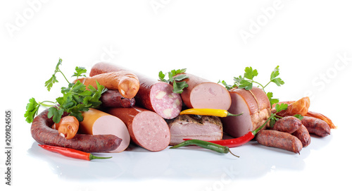Different sausages and smoked meats isolated on white .