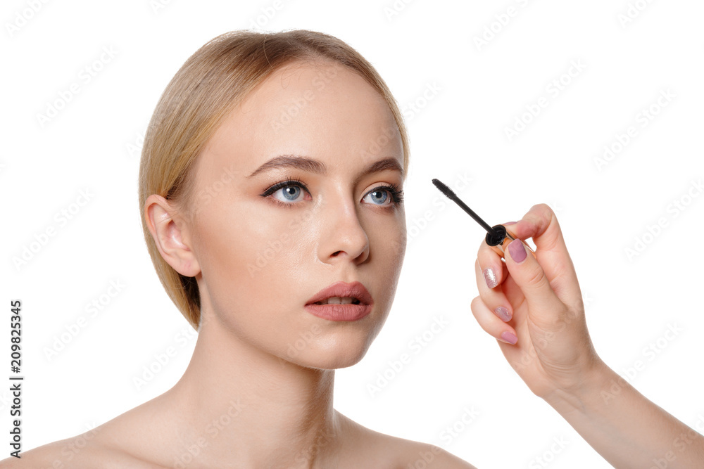 Beauty portrait of a smiling beautiful half naked woman posing with make-up brushes