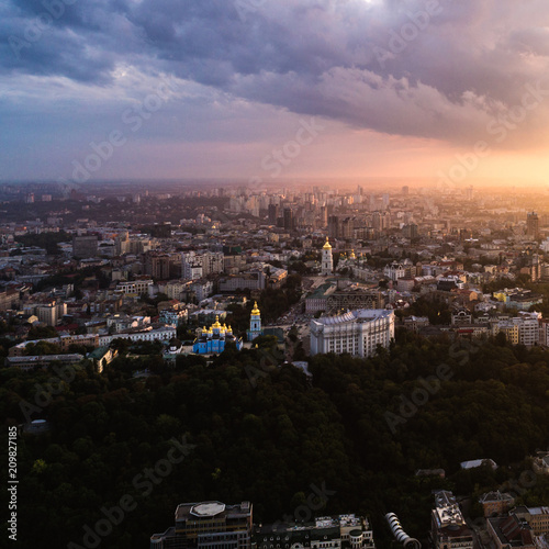 Panoramic view of a modern city at sunset. Skyline bird eye aerial view of the old part of the city under dramatic cloud sunset sky. Vladimirskaya Gorka, St. Andrew's Church, St. Michael's Golden © LALSSTOCK