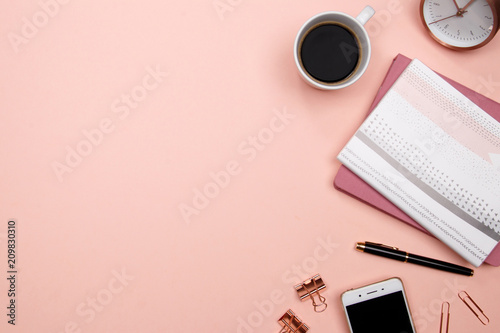 Office table desk with smartphone and other office supplies on pink background. Top view with copy space, flat lay.