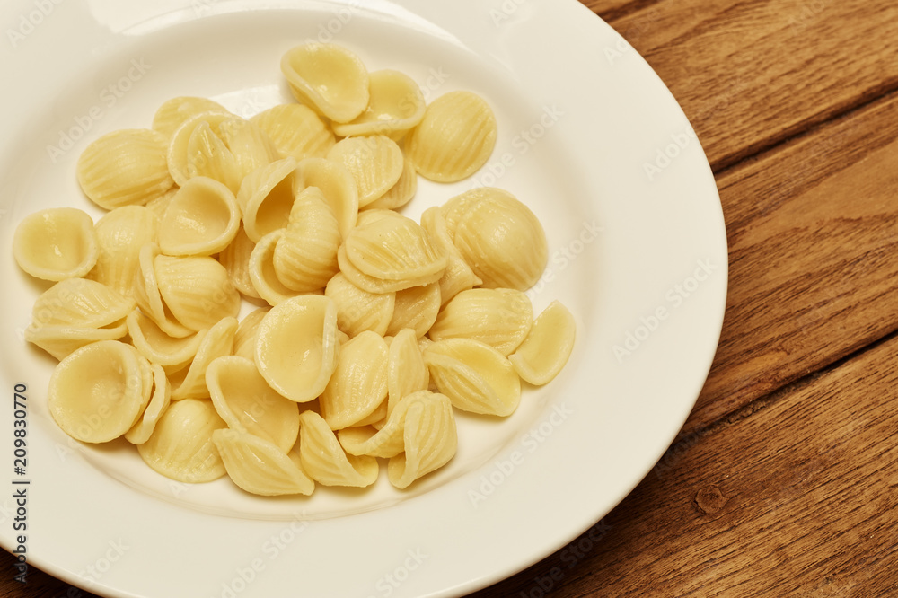 Pasta shell in White Plate on wooden Pasta shell in White Plate on wooden