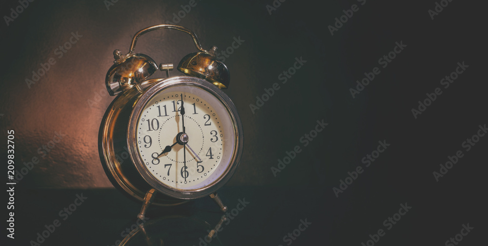 analog system alarm clock old in dark room dim light / photo vintage style and selective focus analog system alarm clock old in dark room dim light / photo vintage style and selective focus