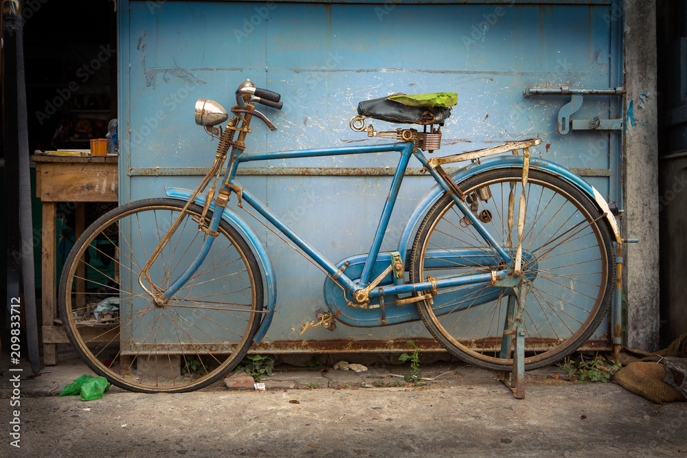 old blue colored bicycle in a street somewhere in the south of india old blue colored bicycle in a street somewhere in the south of india
