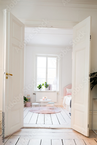 fancy bedroom  white wooden floor open doors looking into the bedroom